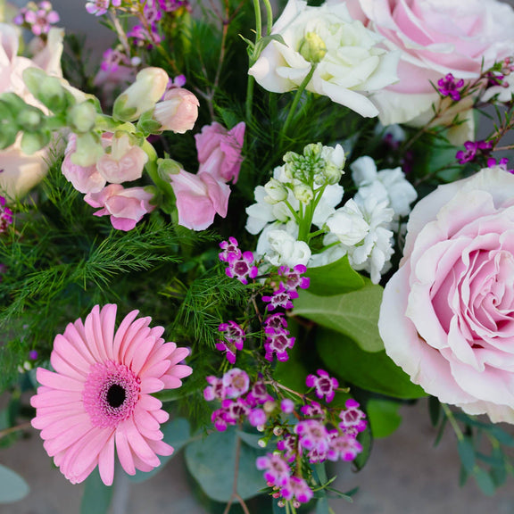 Bouquet of pink and white flowers with greenery on a blurred background