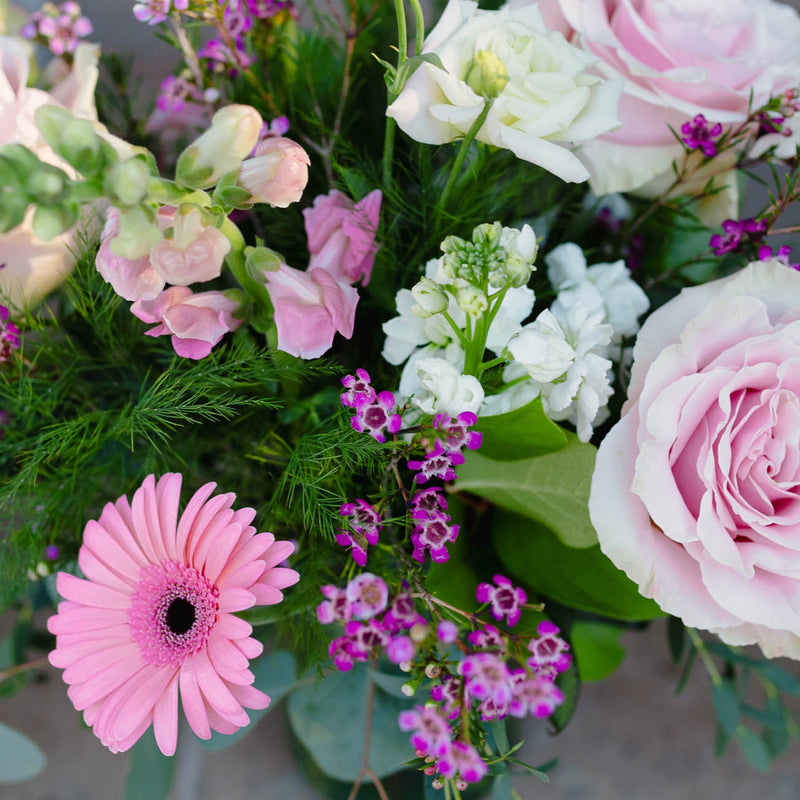 Bouquet of pink and white flowers with greenery on a blurred background
