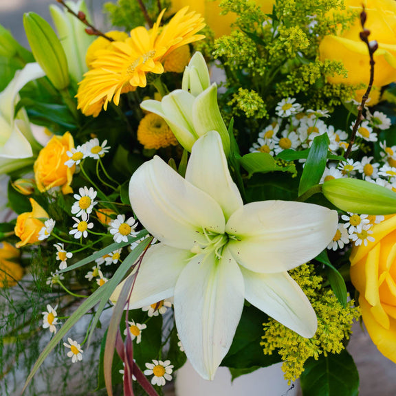 Bouquet of flowers with yellow and white flowers in a vase.