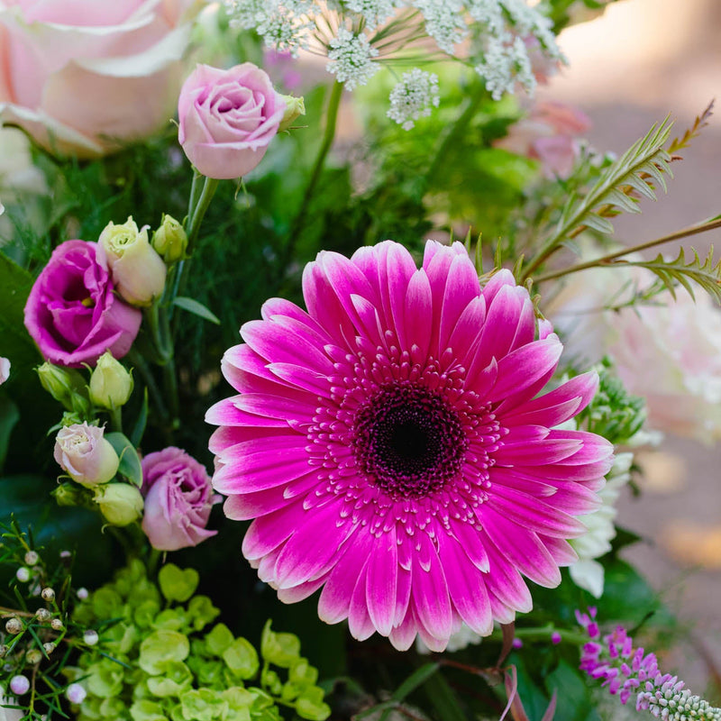 Bouquet of flowers with a prominent pink flower in the center.