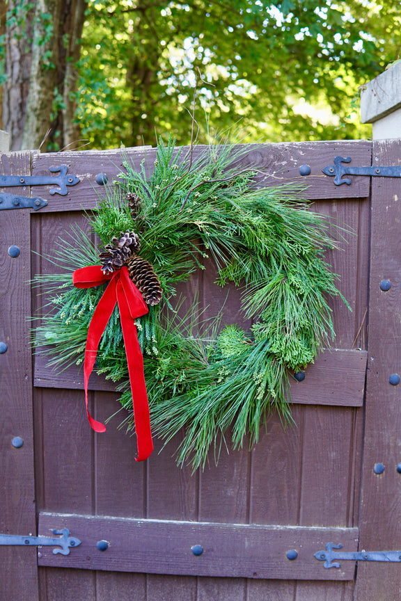Green wreath with red ribbon on a wooden gate