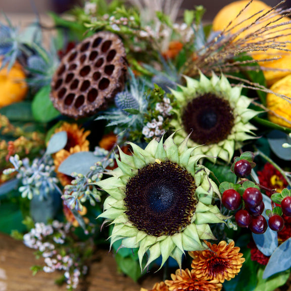 Bouquet of sunflowers, berries, and other flowers with a blurred background