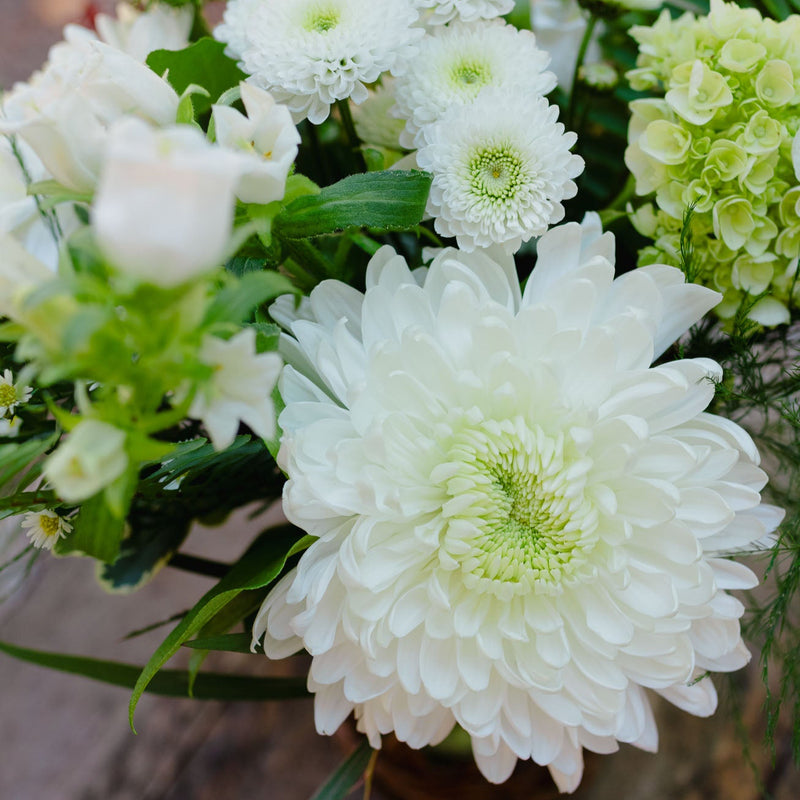 Close-up of a bouquet with white and green flowers on a wooden surface