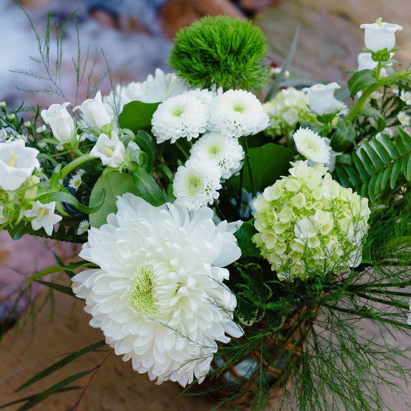Bouquet of white and green flowers on a stone surface