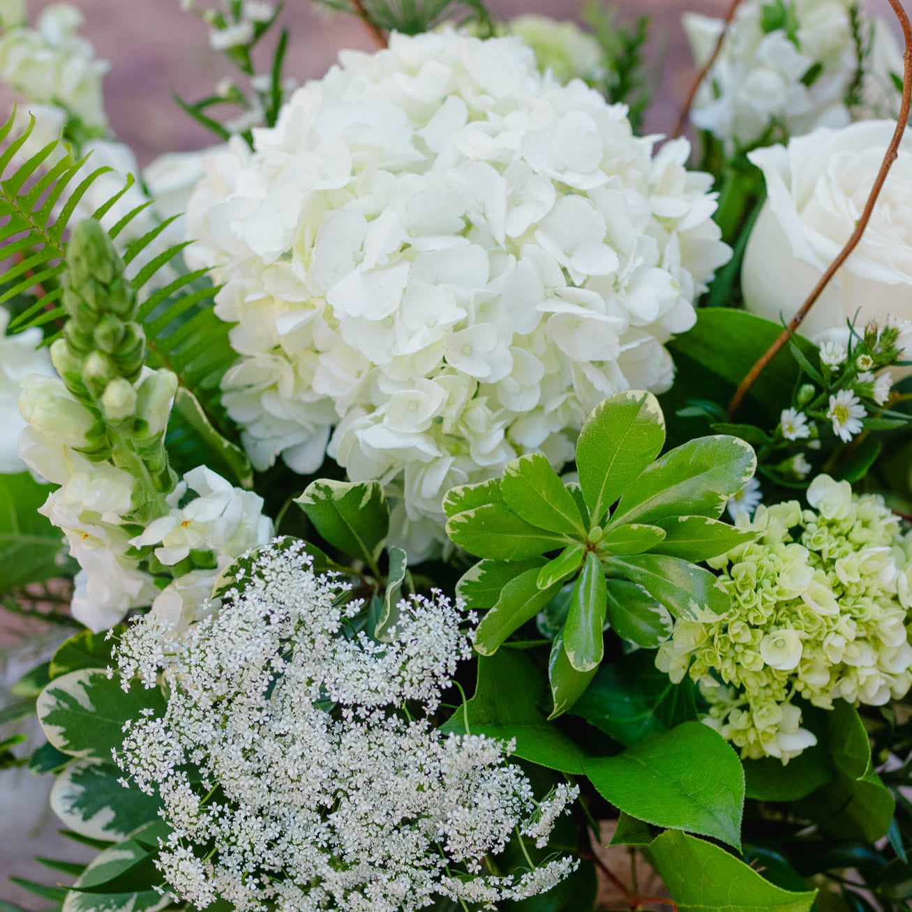 Bouquet of white and green flowers on a wooden surface