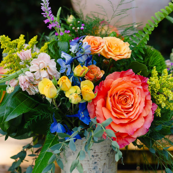 Colorful bouquet of flowers with a pink rose in a vase.