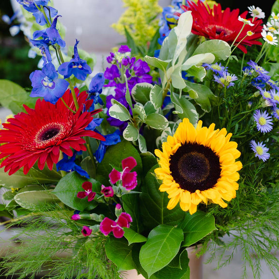 Bouquet of colorful flowers including sunflowers, gerberas, and various other types of flowers.