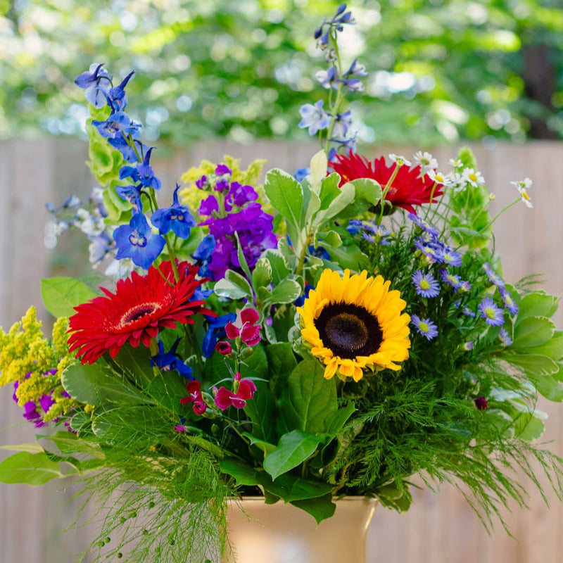Colorful bouquet of flowers in a vase on a table outdoors.